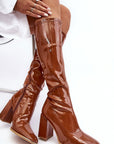 Boots with a glossy brown heel.